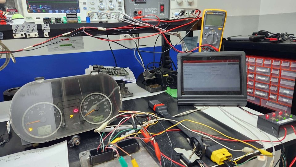 Banco de pruebas de electrónica con un tablero de instrumentos, cableado y una tableta de diagnóstico usados para probar los limitadores de velocidad